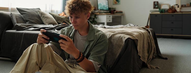 Teenager spielt mit seinem Smartphone